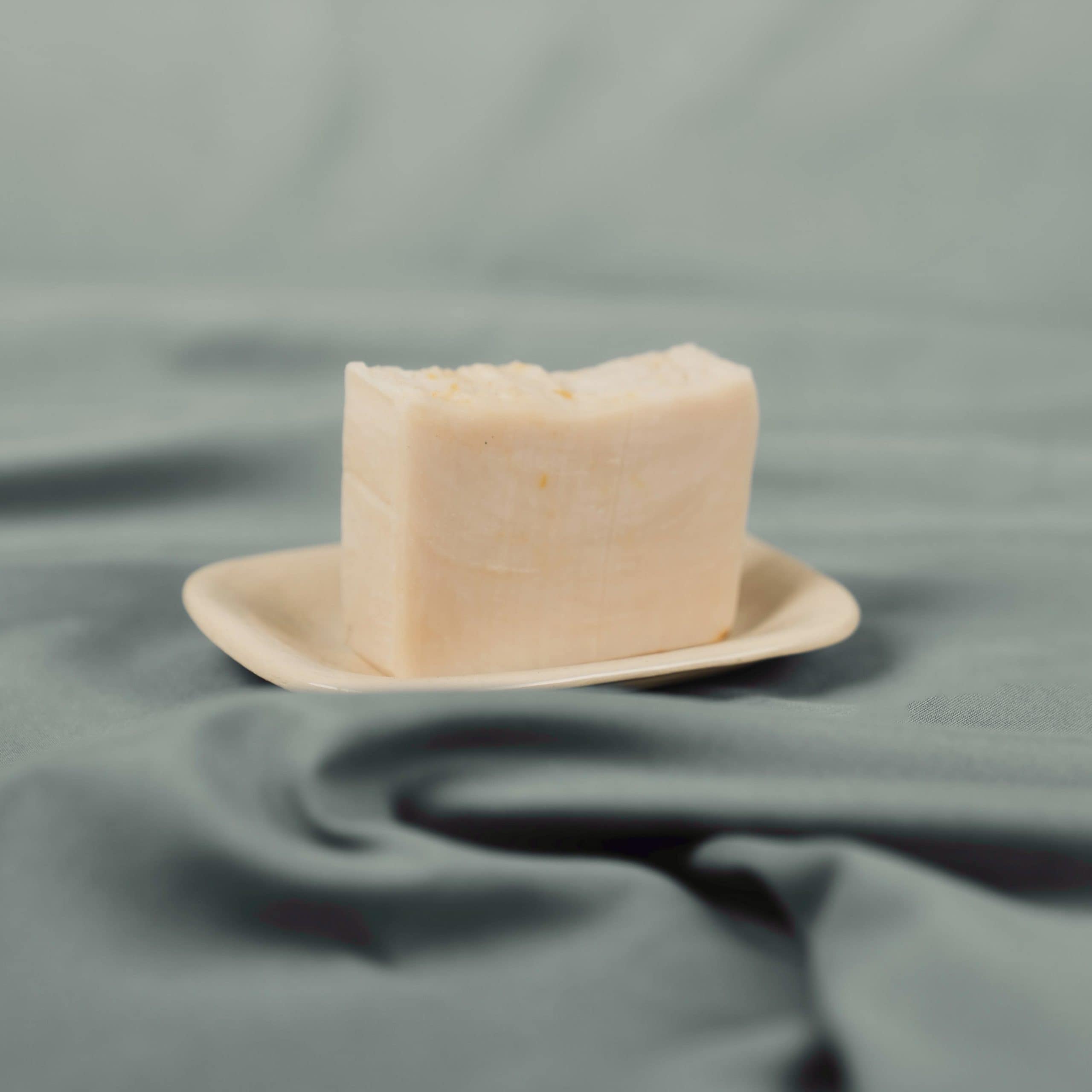 Handmade natural soap bar on a ceramic dish