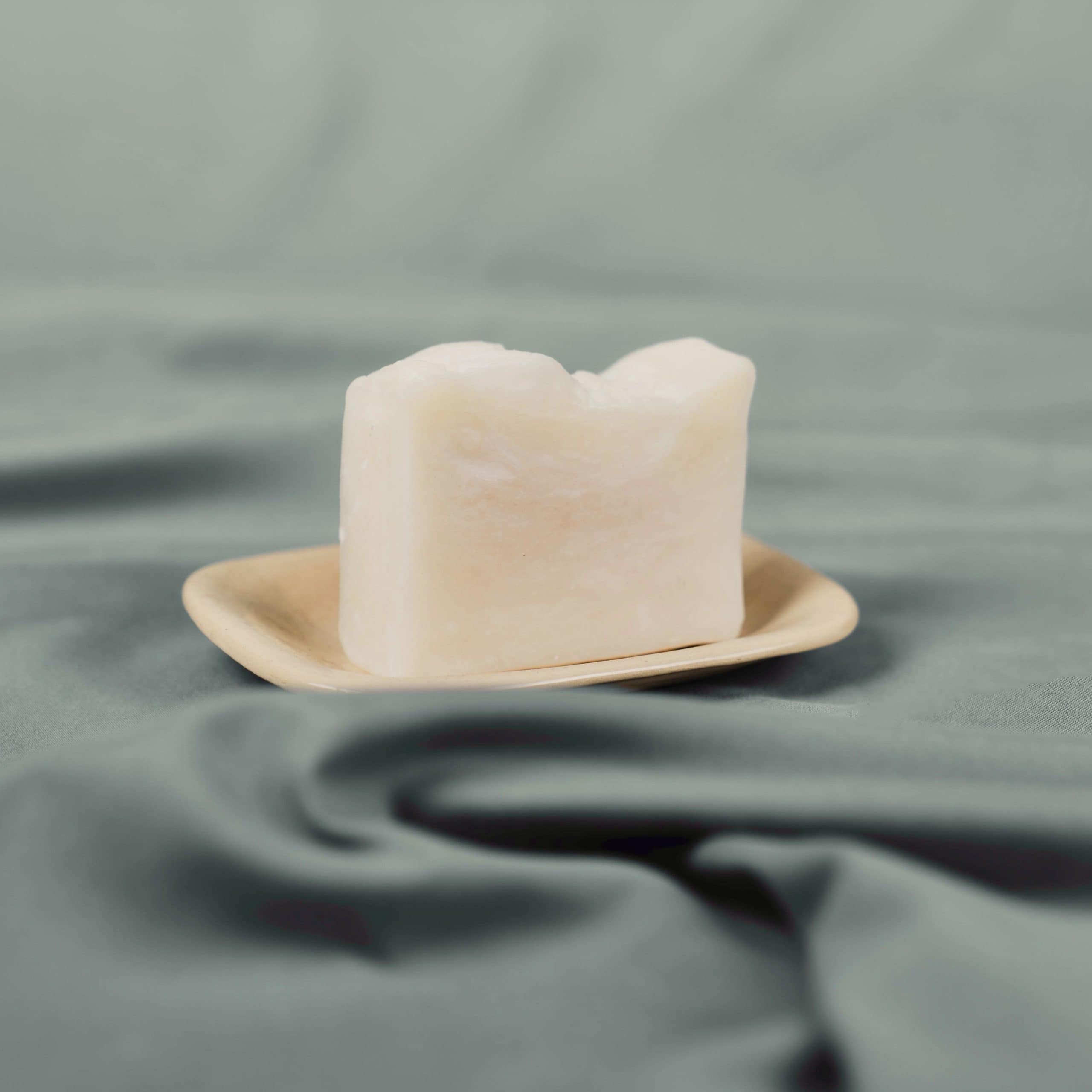 Handmade natural soap bar on a ceramic dish