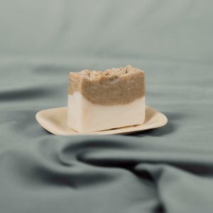 Handmade natural soap bar with two tone brown and white on a ceramic dish
